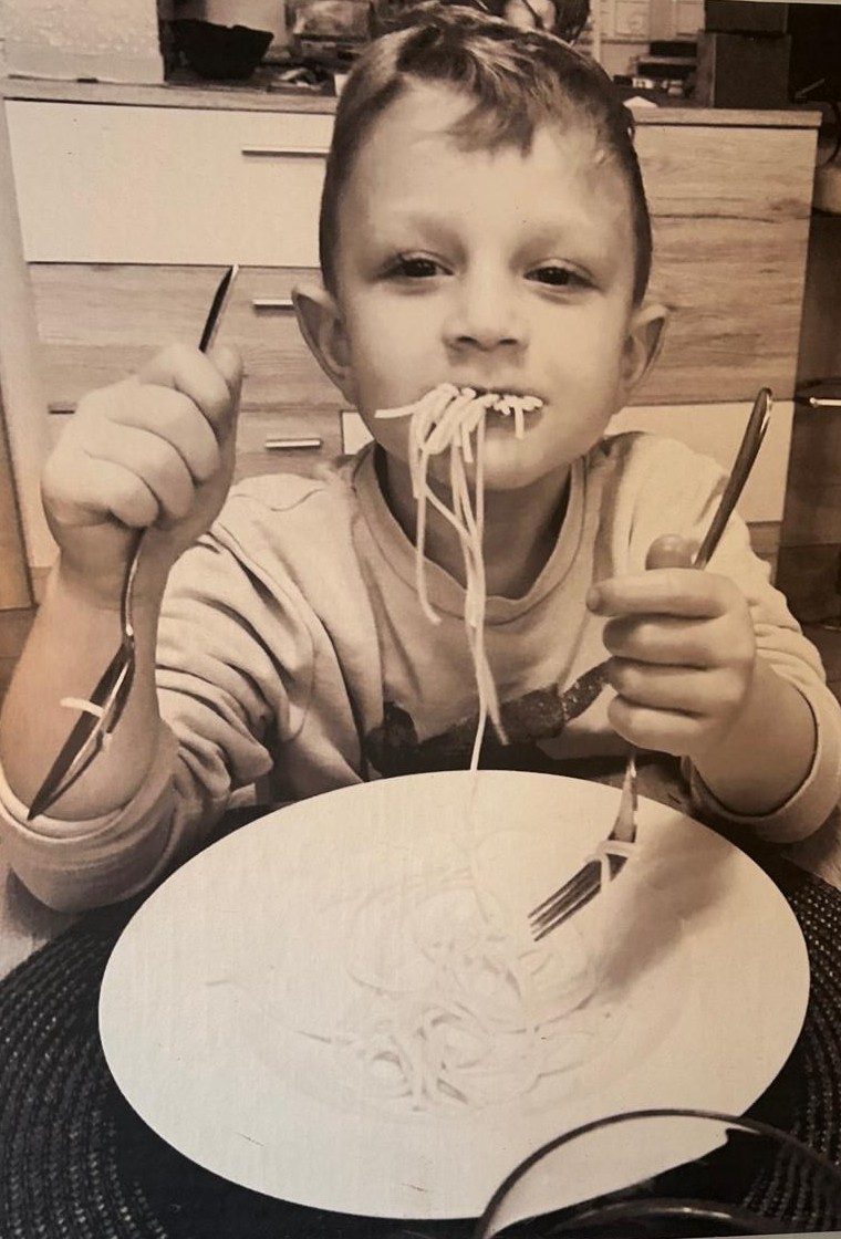 Familienfoto: Kind isst Spaghetti